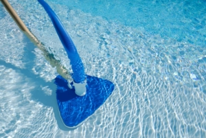 Pool vacuum on bottom of pool floor cleaning debris and dirt 